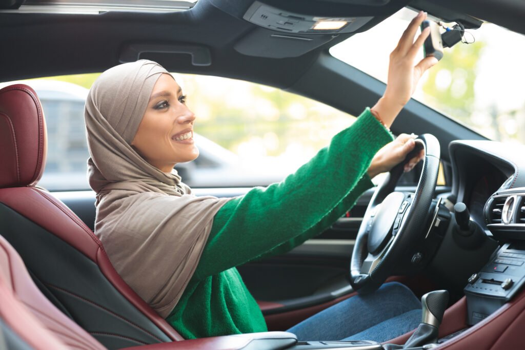 Happy muslim lady driving alone adjusting rearview mirror Solar Gard Surabaya Solar Gard Surabaya