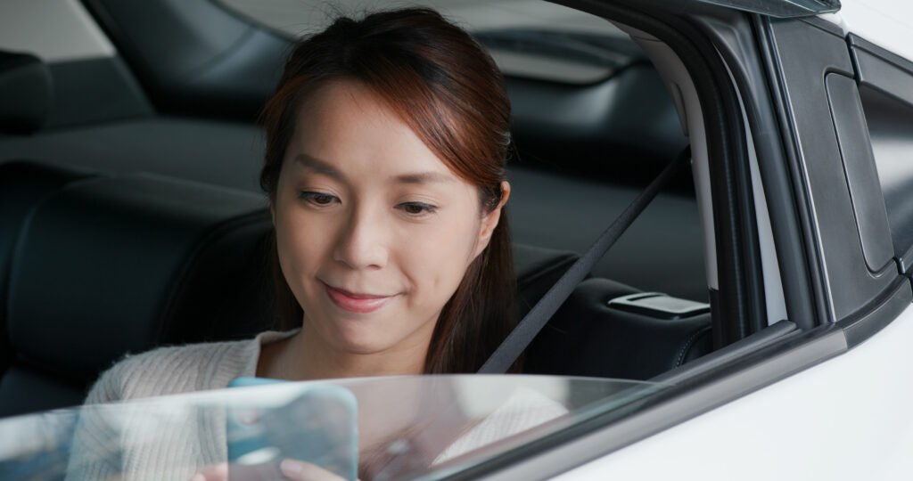 Woman use mobile phone and sits inside car Solar Gard Surabaya Solar Gard Surabaya kaca film